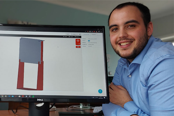 IEEE Student Member Pedro Brandao poses with an on-screen 3D model of his contactless temperature screening device